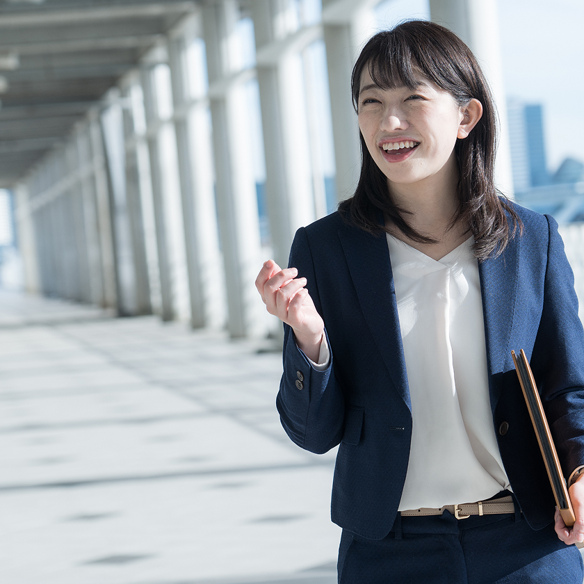 書類を手に笑顔で話す社員
